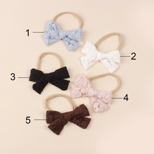 Detail von 5 Spitzen-Schleifen auf weichen Nylon-Stirnbändern in Blau, Weiß und Rosa