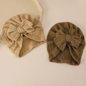 Close-up of baby turban hats with large bows in khaki and coffee brown ribbed knit fabric