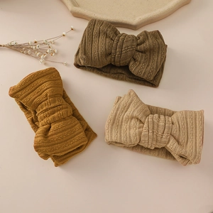 Detailed knit texture of three earth-toned baby bow headbands for newborns