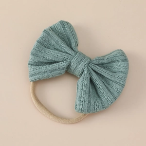 Detailed view of sage green textured jacquard bow on soft nylon elastic baby headband