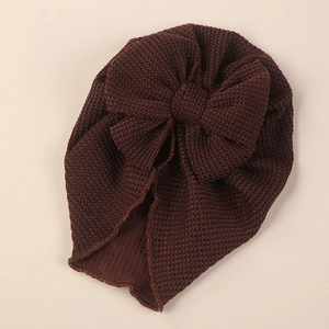Detail of waffle knit fabric texture and large bow on dark brown baby turban hat