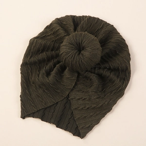 Detail of baby donut hat with dark green cable knit texture and soft fabric finish
