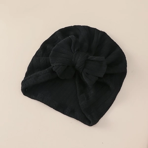 Detail of baby turban hat featuring ribbed texture and a large decorative bow