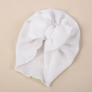 Detailed knit texture of a white baby turban hat with a large bow decoration
