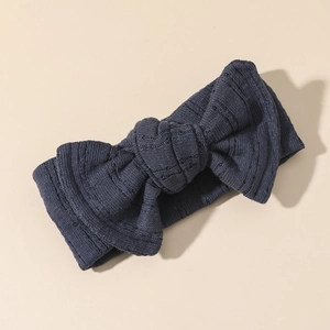Dettaglio della fascia per neonati in cotone lavorato a maglia blu scuro con fiocco a coste