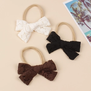 Detailansicht von drei Baby-Stirnbändern mit Spitzenbogen in Weiß, Schwarz und Braun mit Nylon
