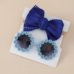Detail view of navy lace bow headband and daisy floral sunglasses for babies