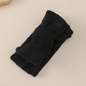 Close-up detail of black ribbed knit fabric baby headband with double-layered bow knot