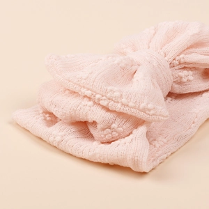 Bandeau bébé rose en maille avec grand nœud à plusieurs couches et finitions pompons