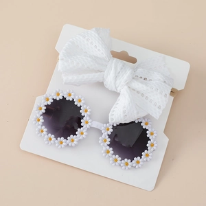 Detail view of baby lace bow headband and daisy sunglasses on display card