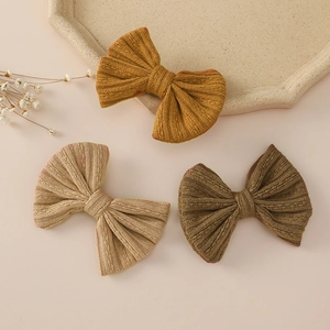 Detailed macro view of knitted jacquard bow hair clips in autumn earth tones