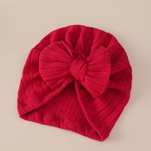 Close-up of red ribbed knit baby turban featuring a large bow and soft texture details