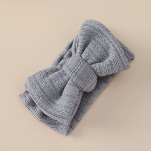 Detailed view of grey knitted baby headband featuring a soft bow and ribbed cable texture
