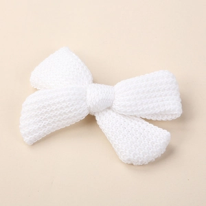 Close-up of white knitted bow hair clip showing dense warp-knitted mesh texture