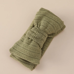 Detail of olive green knitted headband with ribbed texture and DIY double layered bow