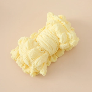 Détail du bandeau bébé jaune clair avec un grand nœud et une texture gaufrée seersucker