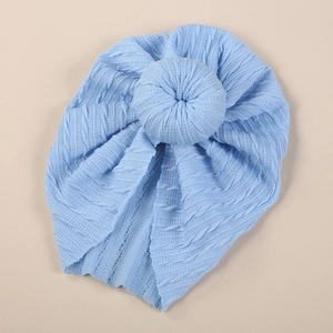 Detail of baby donut turban hat with soft ribbed knit texture in light blue color