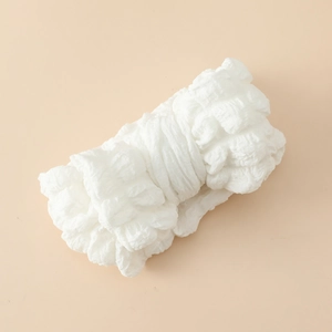 Vue détaillée de la texture du tissu popcorn blanc sur un bandeau bébé souple
