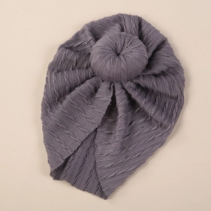 Detail of grey cable knit baby turban hat showing soft texture and donut knot