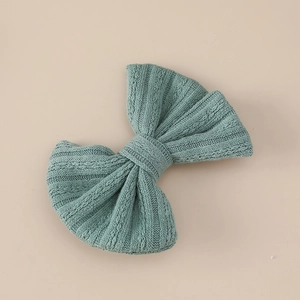 Detail of Morandi green jacquard bow hair clip with a soft ribbed knitting texture