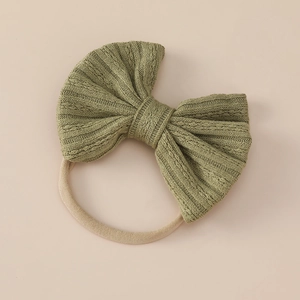 Close-up of soft nylon baby headband with grass green ribbed jacquard bow detail