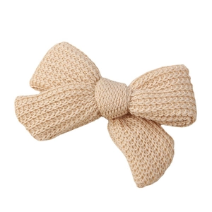 Knitted bow hair clip for toddlers in apricot cream color with crochet texture