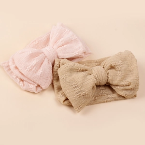 Détail de bandeaux bébé rose et sable avec des nœuds en maille double couche