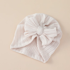 Detailed texture of baby turban hat featuring a large soft bow and vertical ribbing