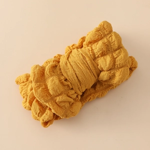 Détail du bandeau jaune gingembre avec tissu plissé doux et détails de texture gaufrée