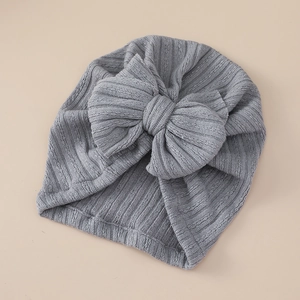 Detailed view of grey ribbed knit baby turban hat with a large decorative bow