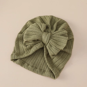 Detail of olive green ribbed knit baby turban hat featuring a large soft bow decoration