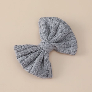 Detail shot of a grey textured knit bow hair clip with vertical ribbed stitching