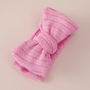 Close-up of pink jacquard double-layered bow baby headband with soft ribbed knit texture