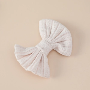 Close-up of a soft knitted jacquard bow hair clip with detailed ribbed texture for girls