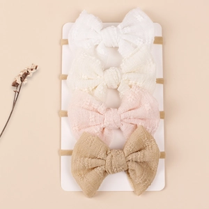 Set of 4 soft nylon baby headbands with textured mesh bows in neutral colors