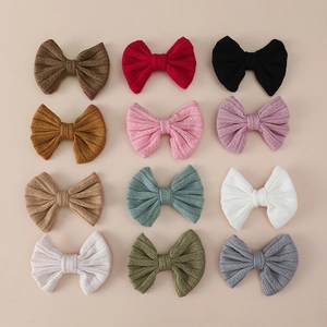 Detail view of 12 colorful ribbed knit bow clips for girls in a grid display