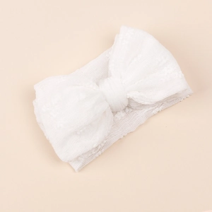 Gros plan d'un bandeau blanc pour bébé en tulle avec un grand nœud en dentelle
