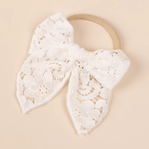 Close-up of white hollow lace double-layer bow headband with soft nylon band