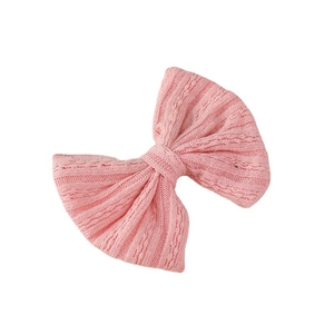 Pink jacquard knit bow hair clip for girls with ribbed texture on white background