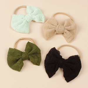 Detail of four colorful nylon baby headbands with waffle texture fabric bows
