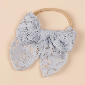 Detail of light blue floral lace bow on highly elastic nylon headband for infants