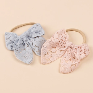 Detailed macro view of soft nylon baby headbands with delicate lace bow knots in pastel colors