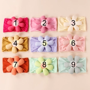 Detailed grid view of nine colorful elastic baby headbands with soft padded fabric flowers