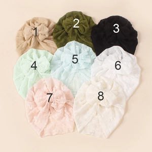 Detail of baby turban hats in 8 colors with large bows and soft dotted knit texture