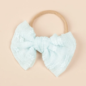 Detail of baby headband featuring light blue lace bow and soft elastic nylon band