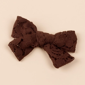 Close-up of vintage brown lace bow hair clip showing intricate hollow crochet texture