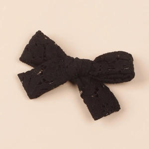 Detailed view of vintage black lace bow hair clip with intricate hollow embroidery pattern
