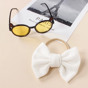 Detail of white waffle bow headband with soft nylon band and cute kids sunglasses
