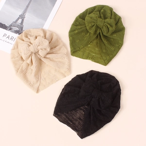 Detailed view of soft knit baby turbans with large bow in beige, olive, and black colors