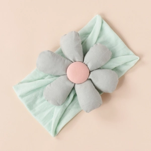 Detail of baby headband with mint green fabric and handcrafted 3D stuffed cotton flower
